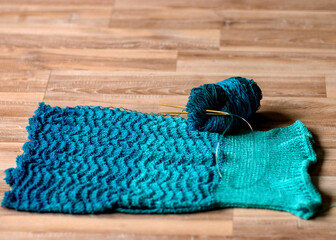 Fototapeta na wymiar a fragment of a blue knitted sweater of different shades, leisure concept, handmade
