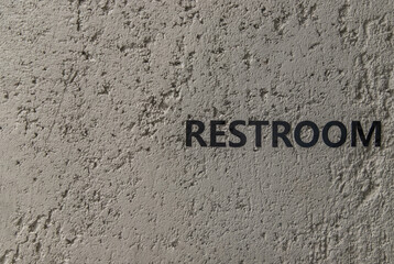 Restroom : signage in black letters. Characters on the bare cement wall background. Toilet sign, Restroom Concept, WC signs for restroom. No focus, specifically.