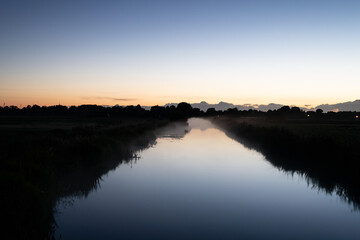 Obraz premium a river glows at night with the horizon along with dark landscape
