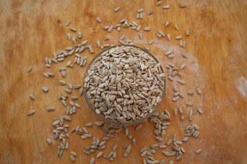 Sunflower seeds in a bowl on a wooden background
