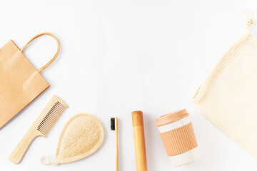 Set with reusable items on white surface. Bamboo toothbrush, wooden hairbrush, paper kraft bag, grocery mesh bag, coffee mug. Sustainable lifestyle. Zero waste, plastic free concept. Copy space