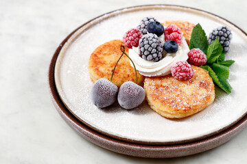 a plate with cheese cakes and berries