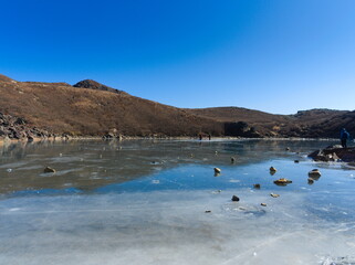 青空と凍った火口湖