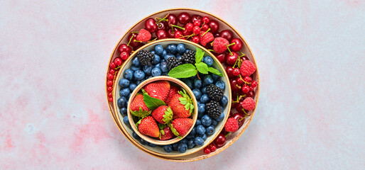 Obraz na płótnie Canvas Blueberry, raspberry, blackberry, redcurrant, strawberry, cherry in bowl. Fresh blueberry, berries mix on marble. Red raspberry, blue blackberry, mint creative composition. Colorful