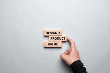 Product marketing concept. Business marketing words demand, product and value written on wooden blocks with a male hand