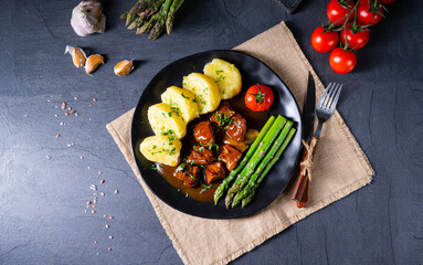 dumplings with beef goulash and green asparagus