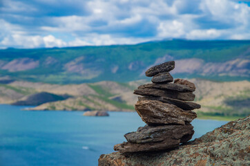 Zen concept. A pyramid made of stone on top of a mountain against the backdrop of Lake Baikal. Stone pyramid for meditation. Harmony and Meditation. Zen stones.