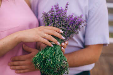 Bunch of lavender flowers in hands of loving couple