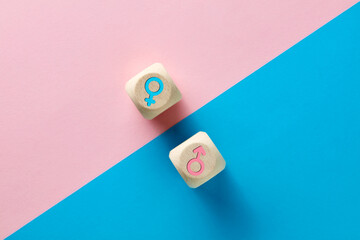 Male and female sex icons on wooden cubes on pink and blue background. Sex change, gender reassignment, transgender and sexual identity concept. - obrazy, fototapety, plakaty