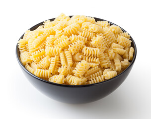 Uncooked radiatori pasta in black bowl isolated on white background with clipping path