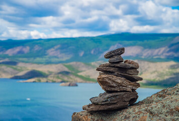 Zen concept. A stone object on the top of a mountain against the backdrop of Lake Baikal. Stone pyramid for meditation. Harmony and Meditation. Zen stones.