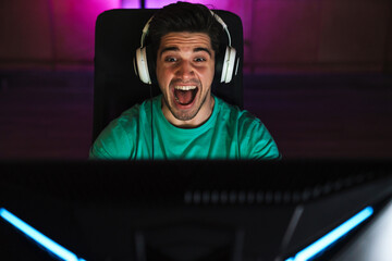 Image of caucasian excited man playing video game on computer