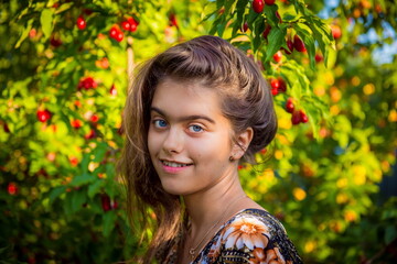 Portrait of a beautiful girl outdoor.  girl in the garden. Vacation in the village. Girl and dogwood tree. Summer berry harvest
