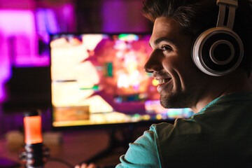 Image of caucasian happy man playing video game on computer