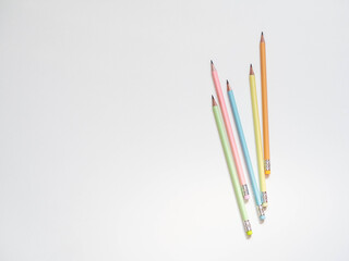 Multicolored pastel graphite pencils on white background. Flat lay, top view, concept for business, school, girl blogging lifestyle