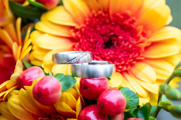 Silver Wedding Ring on yellow and red flowers as symbol of love and human relationships commitment