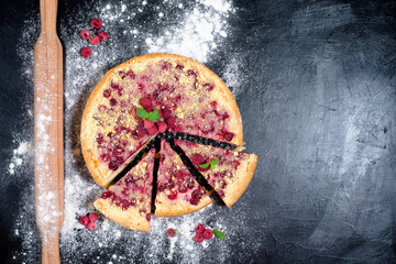 Obraz na płótnie Canvas raspberry pie with ripe raspberries in home cooking with cottage cheese on a dark background, top view place for text