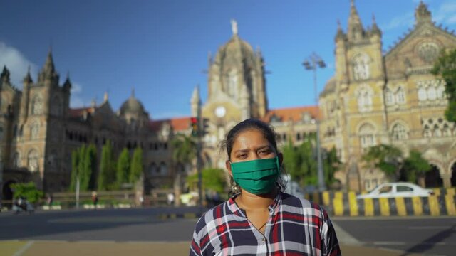 Young Girl Wearing Mask Standing Front Of Chhatrapati Shivaji Terminus (CST) formerly Victoria Terminus, is a UNESCO World Heritage Site, Mumbai