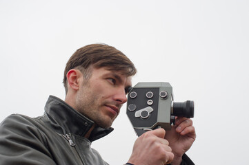 man holding a movie camera in his hands makes filming.