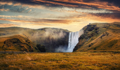 Incredible Icelandic Landscape. Famous Skogafoss waterfall with colorful sky during sunset. Skoga...