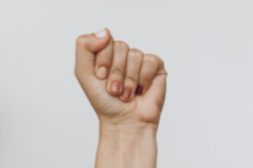 Fist protesting. Blurred image of female fist protesting on white background. Female hand raised up with different nails colors, skin and race diversity. Women rights and Stop racism concept