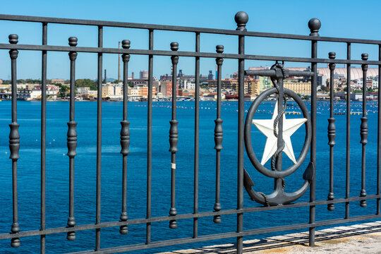 Close up of the railing in Taranto on blurred industrial site called Ilva background