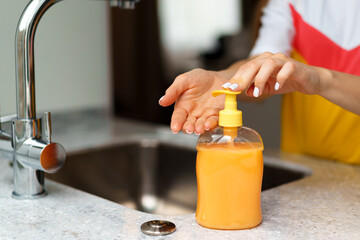 Close up of a woman washing her hands in a kitchen sink