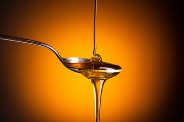 Organic honey flowing from the spoon