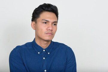 Portrait of handsome Asian businessman thinking and looking away