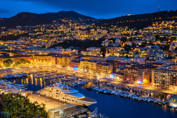View of Old Port of Nice with luxury yacht boats from Castle Hill, France, Villefranche-sur-Mer, Nice, Cote d'Azur, French Riviera in the evening blue hour twilight illuminated
