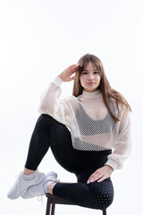 Fototapeta premium A girl in sweatpants, top and jacket poses on a white background. Fashion photography of clothing