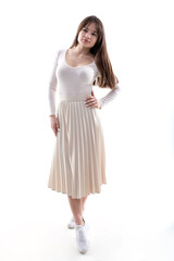 Beautiful girl in a white blouse and skirt posing on a white background