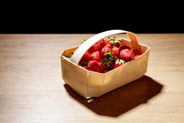 strawberries in the basket on a wooden table