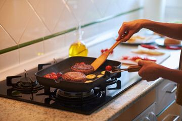 Cooking two delicious hamburgers on a grill.