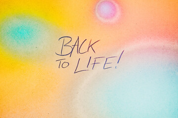 Schrift Back to Life auf buntem Hintergrund aus Papier