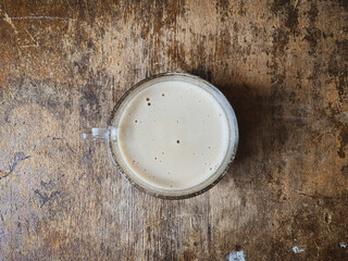 a cup of cappuccino on an old table