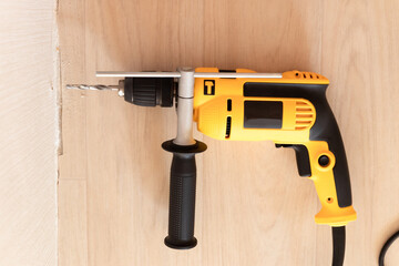 Drilling a hole in the wall with a drill. Repair and construction in the house
