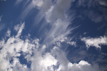 Fototapeta na wymiar Cumulus and cirrus clouds on a blue sky in sunny weather