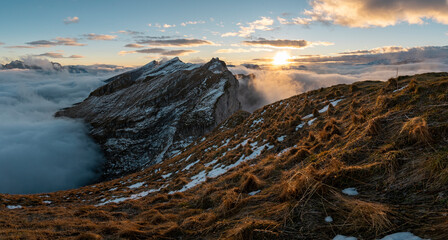 Panorama of colourful sunrise over the clouds on a mountain top in the Swiss alps