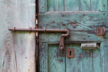 Old iron bold on rustic wooden door in Bigorio village, Switzerland