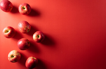 Top view,  Group of red apples on red paper background with copy space.