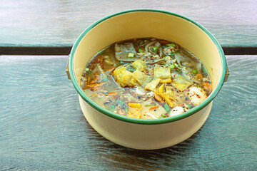 Spicy noodle soup with pork put the Pinto on wooden.