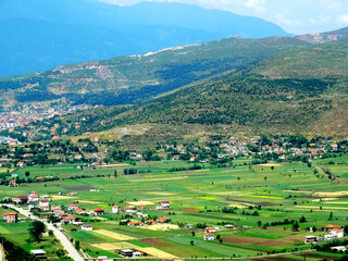 Fototapeta na wymiar Natural countryside landscape with agricultural crops in valley field beside mountains. Transportation way from Macedonia to Albania.