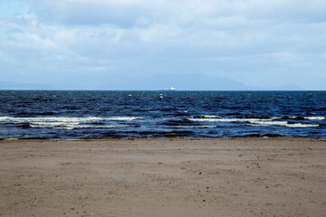 Fototapeta na wymiar Distant Cargo Ship From a Deserted Beach