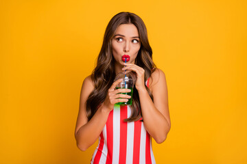 Obraz premium Close-up portrait of her she nice attractive lovely cute girlish feminine glamorous girl drinking juice beverage exotic tour voyage isolated on bright vivid shine vibrant yellow color background