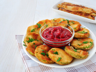 Crispy fried zucchini slices coated in breadcrumbs with a bowl of ketchup