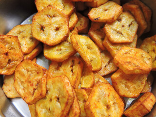 Raw banana fried slices kept in a container. Raw banana or plantain is used as vegetable in many parts of India. 