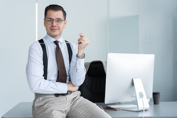 Portrait of a confident young businessman standing alone in a large modern office near his workplace