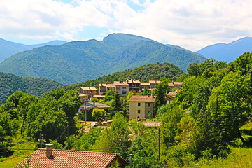 Fototapeta na wymiar fondo paisaje con panorámica de un pequeño pueblo entre valles y montañas en verano