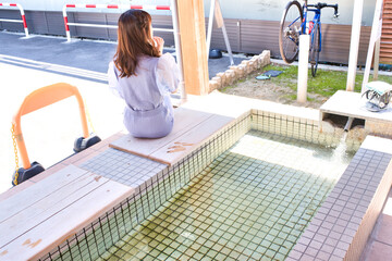 足湯に入浴中の若い女性